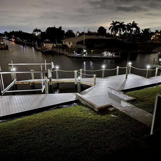 Dock and walkway lit up at night with piling lights