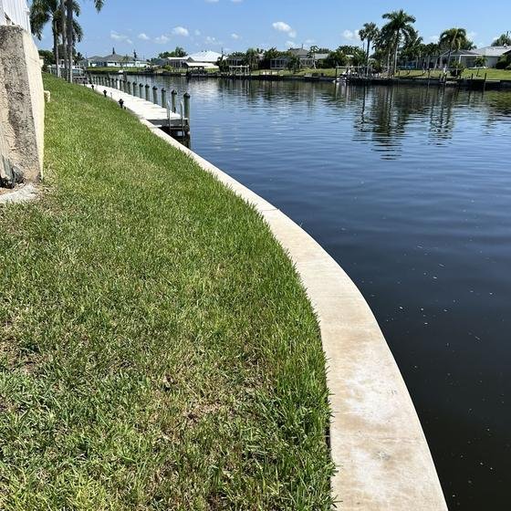 Curved concrete seawall cap along the canal